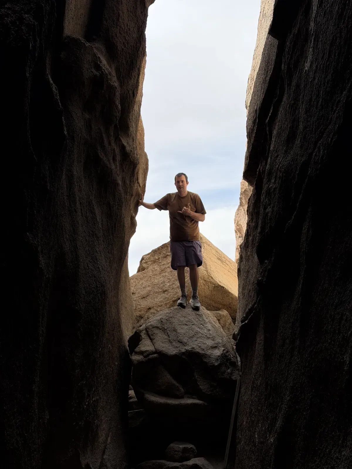 Kevin, after weight loss, standing on a boulder between tall rock formations